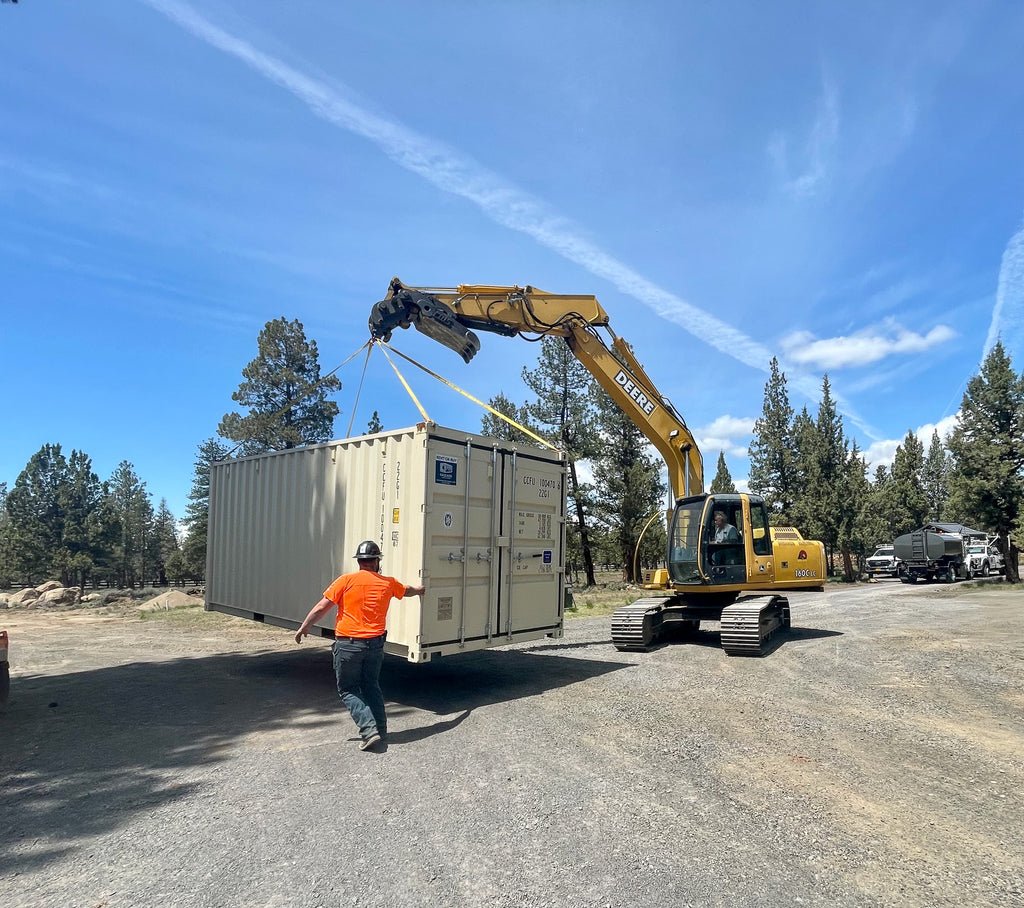 Cascade Crate - 20' storage container being moved by an excavator.